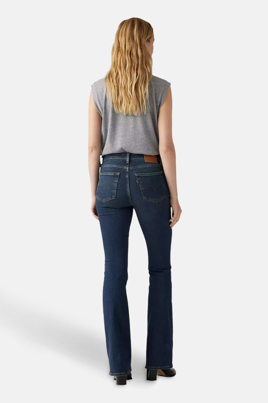Wijd uitlopende jeans van donkerblauw denim van Levi's, gedragen met een grijs mouwloos T-shirt, achterzicht.