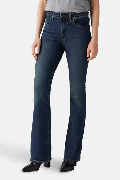 Uitlopende jeans in donkerblauw denim van Levi's®, gedragen met een grijze top en zwarte schoenen.