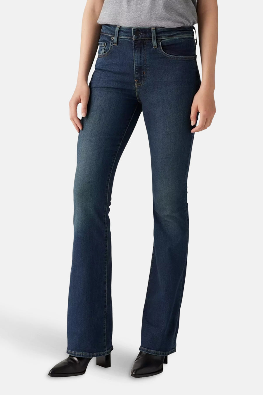 Uitlopende jeans in donkerblauw denim van Levi's®, gedragen met een grijze top en zwarte schoenen.