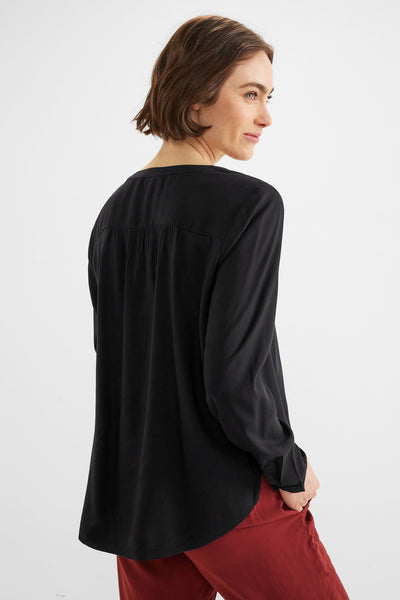 Blouse noire à manches longues de Street One, avec des plis discrets au dos et un ourlet arrondi.
