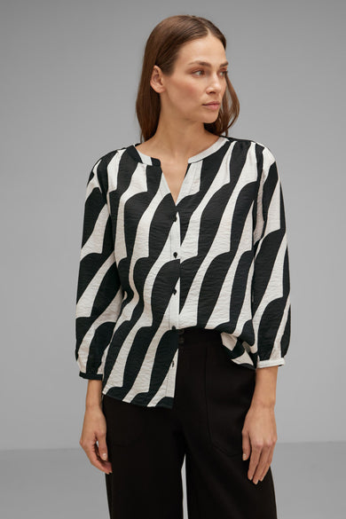 Chemisier noir à manches longues de STREET ONE, motif zébré ondulé noir et blanc, porté avec un pantalon noir.
