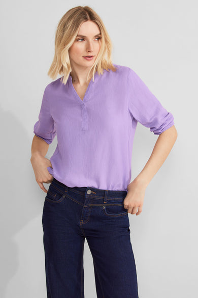 Chemisier 3/4 violet de STREET ONE, porté avec un jean bleu foncé, manches retroussées.
