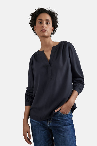 Blauw chemisier met lange mouwen van STREET ONE, gedragen met een jeans en zilveren oorhangers.