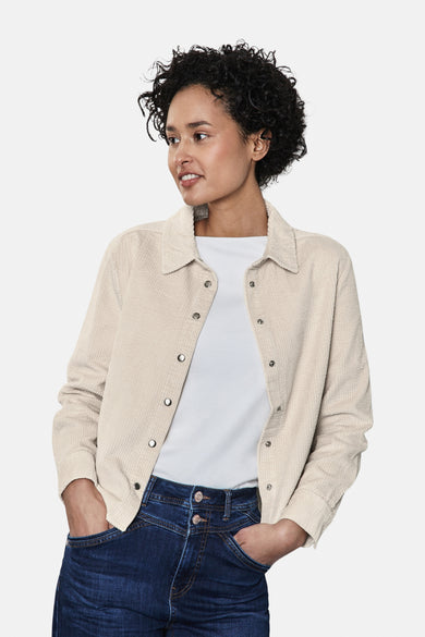 Ecru blouse van STREET ONE met een ribstructuur, gedragen met een wit T-shirt en een blauwe jeans.
