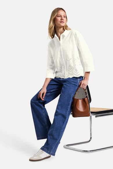 Chemisier blanc à manches longues de Street One avec détails ajourés, porté avec un jean bleu et des baskets.