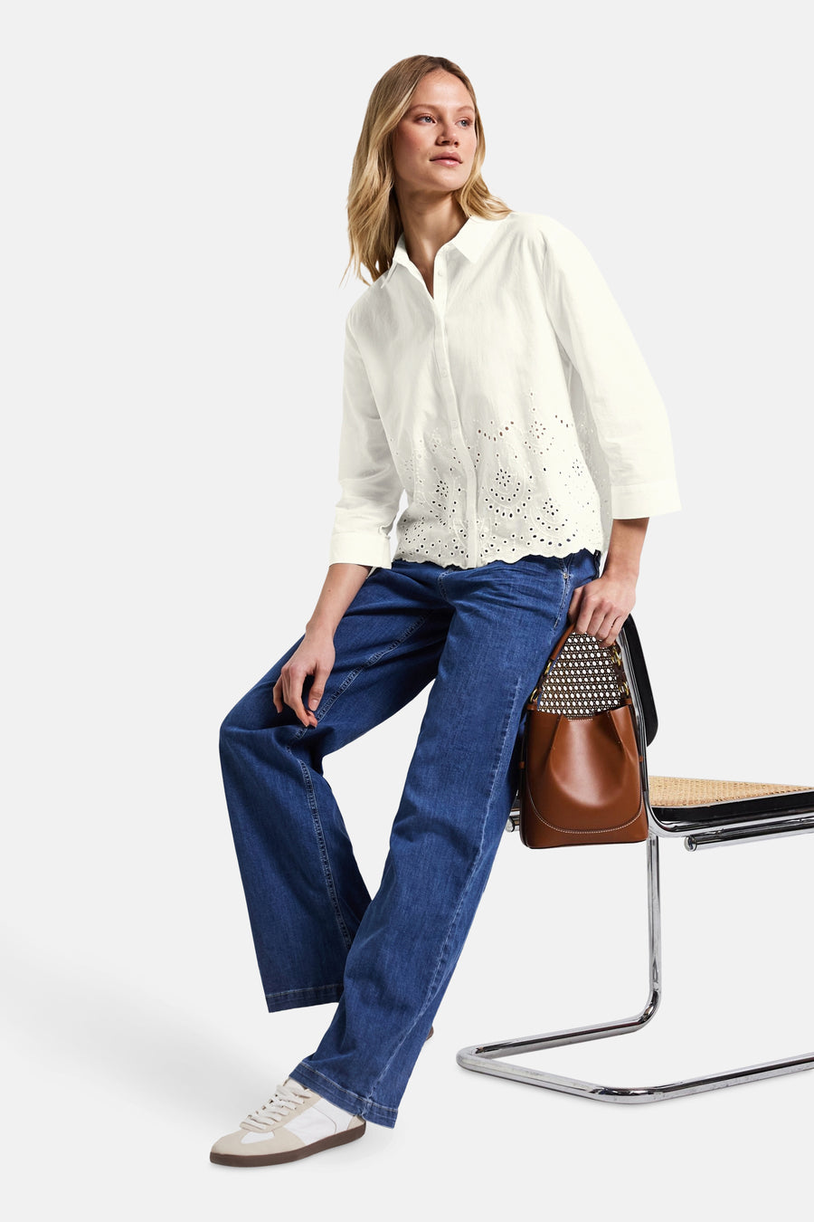 Chemisier blanc à manches longues de Street One avec détails ajourés, porté avec un jean bleu et des baskets.
