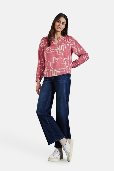 Roze blouse met lange mouwen van Street One, met abstracte patronen, gedragen met een wijde blauwe jeans en witte sneakers.