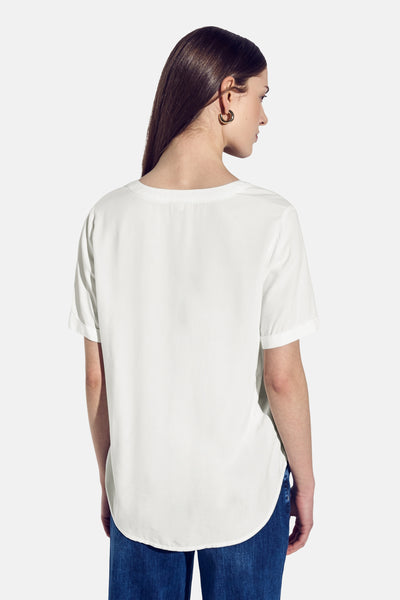 Blouse blanche à manches courtes van STREET ONE, vue de dos, portée avec un jean bleu.