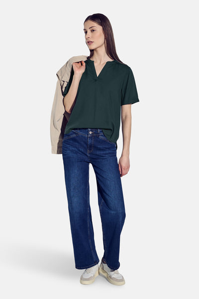 Chemisier vert à manches courtes de STREET ONE, porté avec un jean et une veste beige sur l'épaule.
