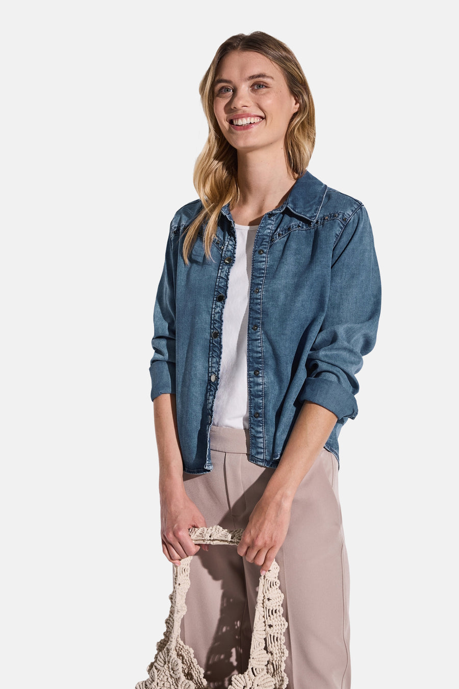 Middelblauwe spijkerblouse van Street One, gedragen over een wit T-shirt en een beige broek.