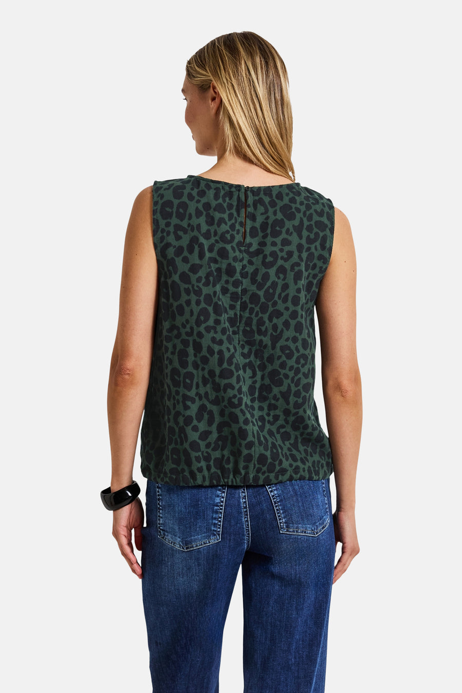 Mouwloos groen overhemd met luipaardprint, van Street One, gedragen met een blauwe jeans en een zwarte armband.