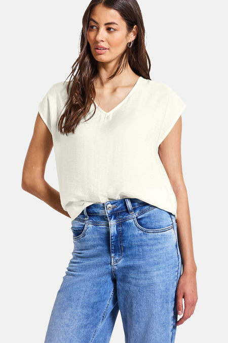 Mouwloos wit overhemd van STREET ONE gedragen met een blauwe jeans.