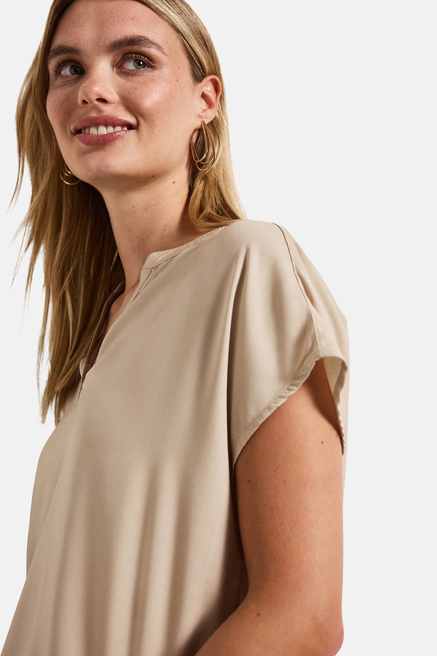 Beige blouse met korte mouwen van Street One, gedragen met gouden oorbellen.