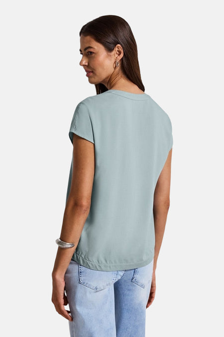 Blouse à manches courtes bleue de STREET ONE, vue de dos, portée avec un jean bleu clair.