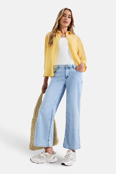 Gele blouse met lange mouwen van Street One gedragen over een wit T-shirt, met een spijkerbroek en een beige tas.