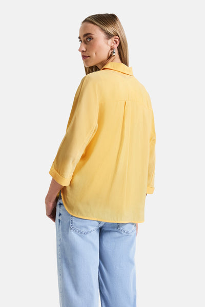 Gele blouse met lange mouwen van STREET ONE, losse pasvorm, plooidetail op de rug, gedragen met een wijde jeans.