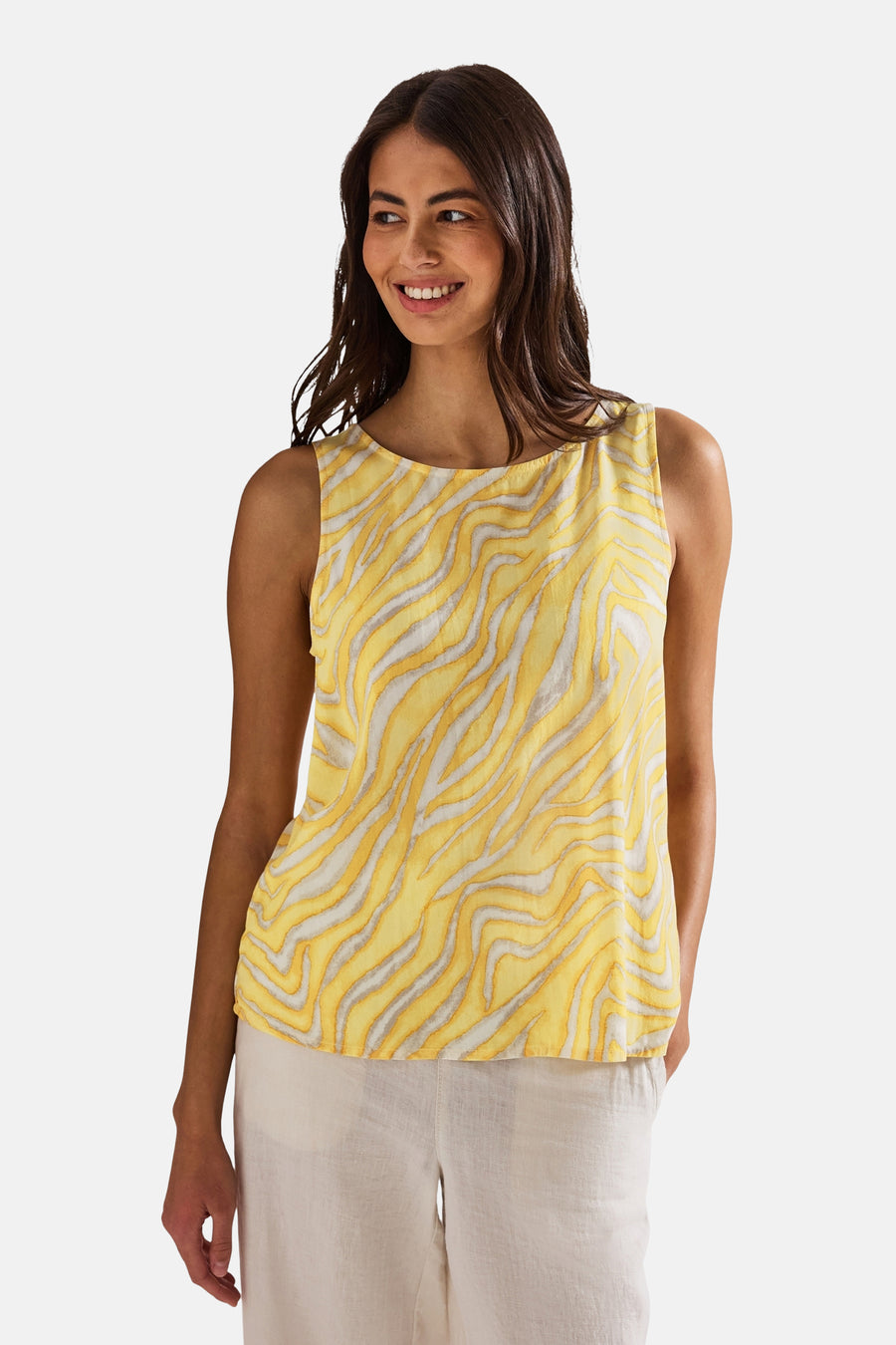 Top sans manches écru de Street One avec motif ondulé jaune et blanc, porté avec un pantalon beige.
