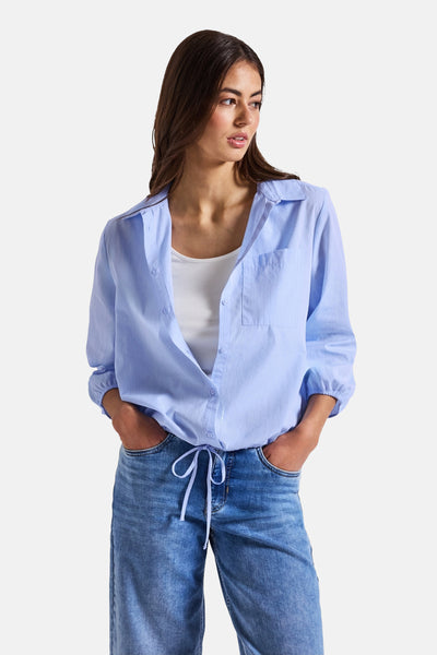Blauwe blouse met lange mouwen van STREET ONE, gedragen open over een witte tanktop, vooraan geknoopt en met een spijkerbroek.