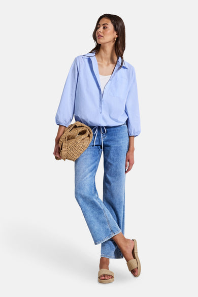 Blauwe blouse met lange mouwen van STREET ONE, gedragen met een witte tanktop, een spijkerbroek en gevlochten sandalen.