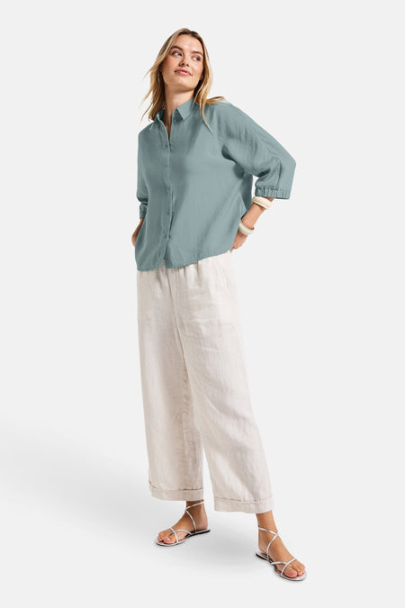 Blauwe blouse met lange mouwen STREET ONE, gedragen met een lichte broek en zilveren sandalen.