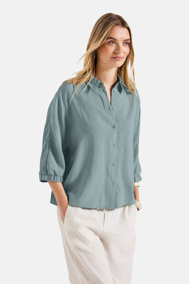 Blauwe blouse met lange mouwen van STREET ONE, met kraag en knopen, gedragen met een lichtbeige broek.