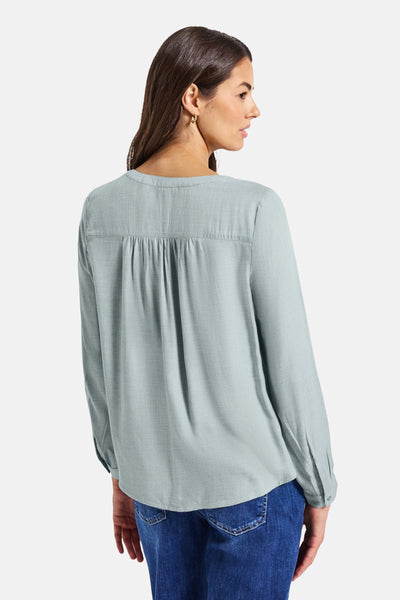 Blauwe blouse met lange mouwen van STREET ONE, met plooitjes aan de achterkant en gedragen met een blauwe jeans.