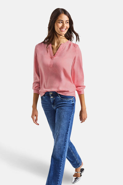 Koraalkleurig overhemd met lange mouwen van Street One, gedragen met een blauwe jeans en zilveren muiltjes.