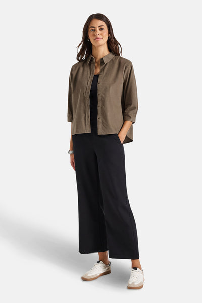 Chemisier beige à manches longues de Street One, porté avec un débardeur noir et un pantalon large.
