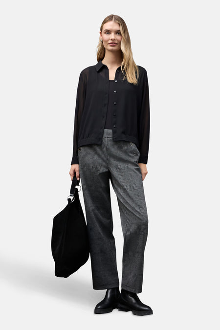 Chemisier noir à manches longues de STREET ONE porté avec un pantalon à carreaux et un sac noir.
