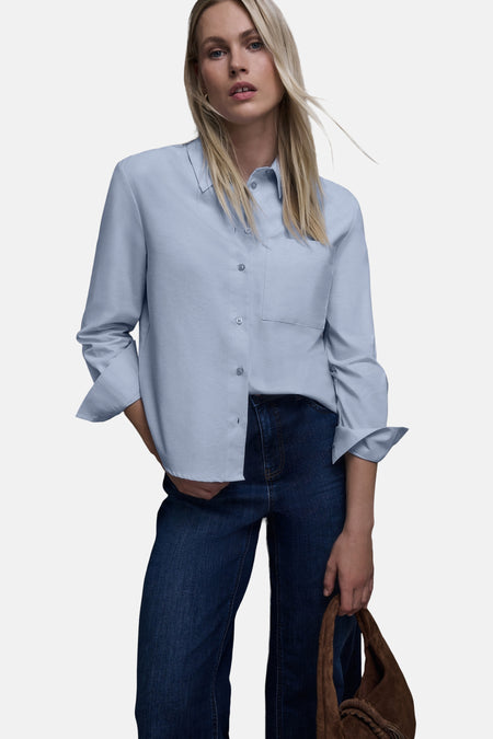 Chemisier bleu à manches longues par STREET ONE, porté avec un jean et un sac à main en daim.
