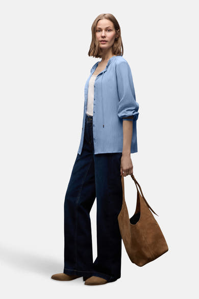 Chemisier bleu à manches longues de STREET ONE, avec texture froissée, porté avec un jean large et un sac en daim.
