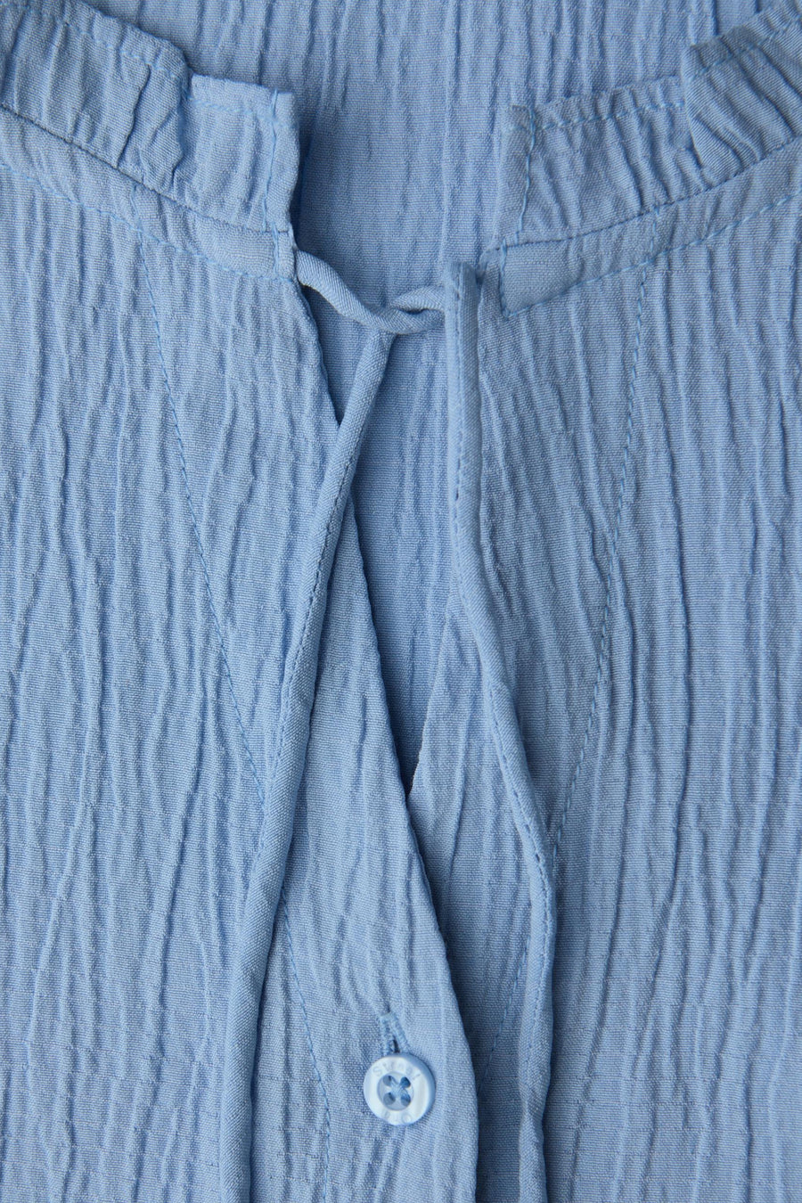 Chemisier bleu à manches longues de Street One, texture gaufrée, col montant avec liens et boutonnière partielle.
