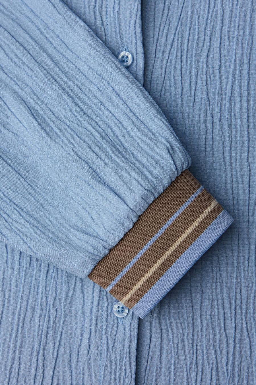 Chemisier bleu à manches longues par Street One, avec texture gaufrée et poignets rayés contrastants.
