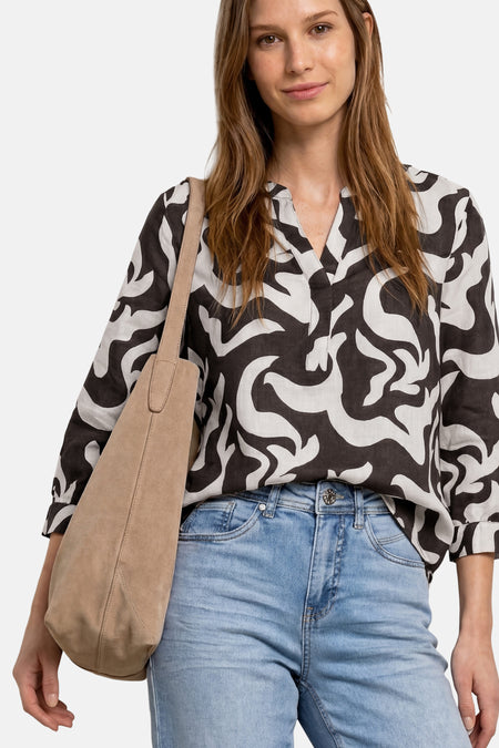 Blouse multicolore de STREET ONE à motif abstrait noir et blanc, col tunisien et manches 3/4, portée avec un jean clair et un sac en daim beige.