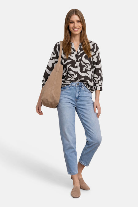 Blouse à manches 3/4 col V et motif abstrait noir et blanc de STREET ONE, portée avec un jean clair.