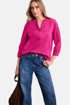 Blouse rose vif à col en V et manches 3/4 de STREET ONE, en tissu texturé, portée avec un jean.