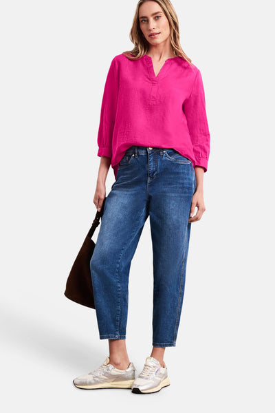 Blouse rose à manches 3/4 de STREET ONE, avec col tunisien et matière texturée, portée avec un jean bleu, des baskets et un sac marron.