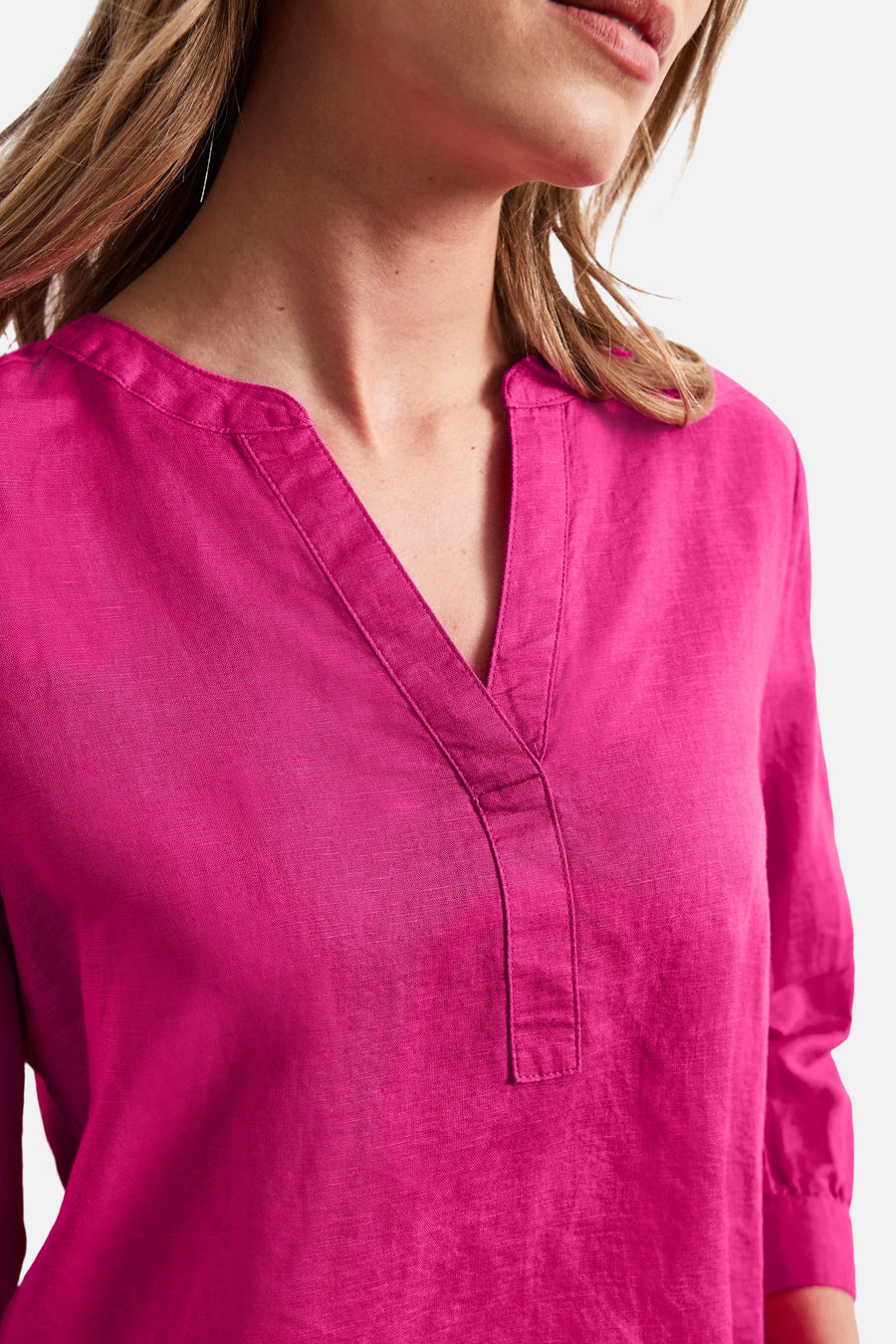Blouse rose de STREET ONE en tissu texturé avec col en V et patte de boutonnage, portée par une femme.