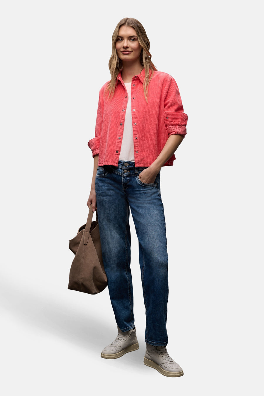 Chemise à manches longues corail par Street One, portée ouverte sur un t-shirt blanc et un jean, avec un sac en daim marron.