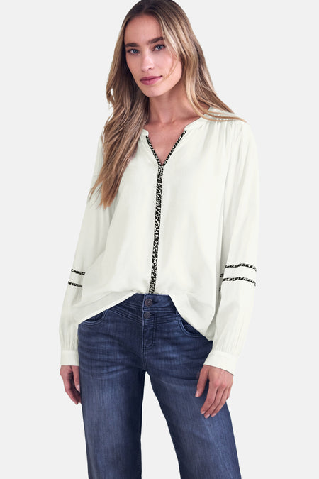 Blouse blanche à manches longues de STREET ONE, ornée de détails léopard au col et aux manches, portée avec un jean taille haute.