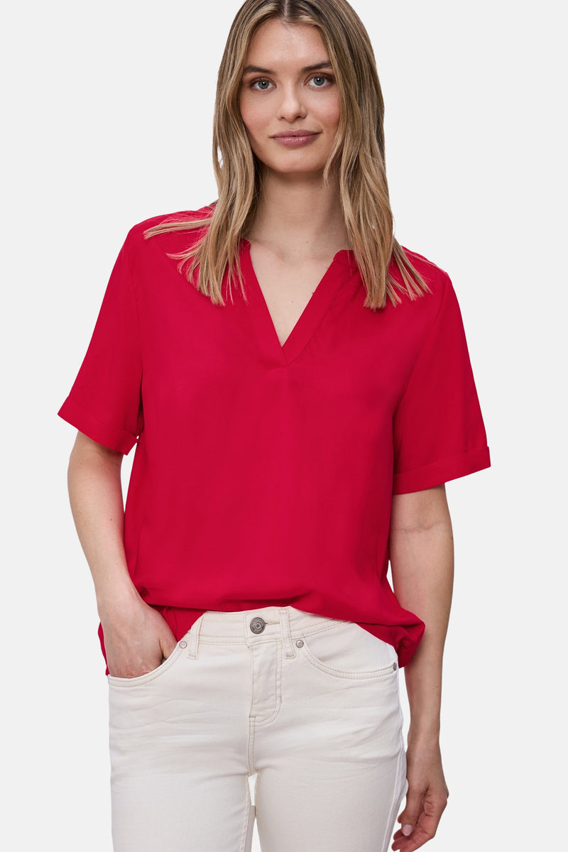 Chemisier rouge à manches courtes de STREET ONE, avec un col en V et porté avec un pantalon blanc.