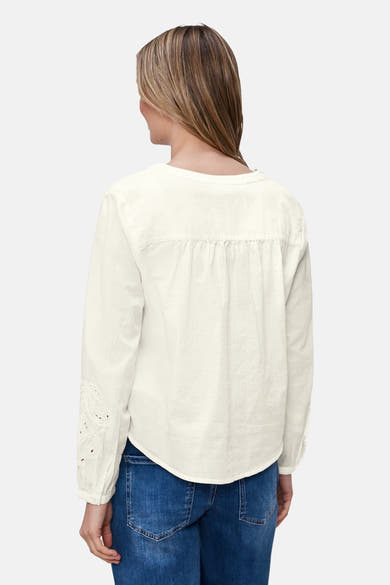 Wit overhemd met lange mouwen van Street One, met broderie anglaise detail op de mouwen, gedragen met een spijkerbroek.
