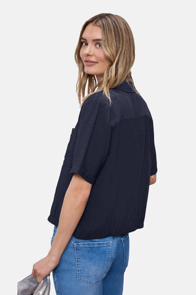 Blauw overhemd met korte mouwen van STREET ONE, kreukeltextuur, met een spijkerbroek en een zilveren tas.