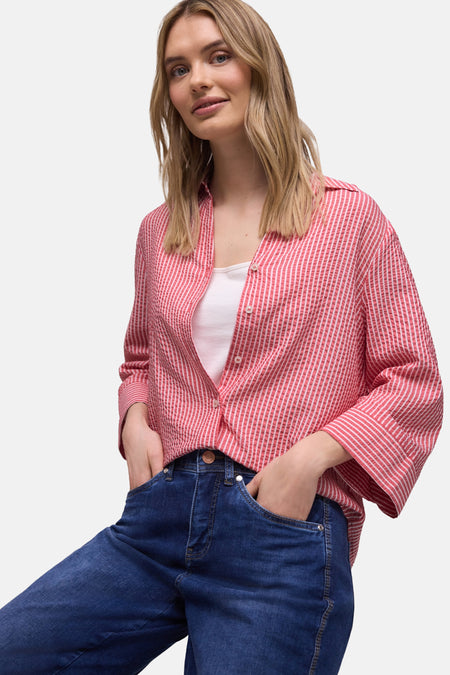 Chemise multicolore à rayures de Street One, portée ouverte sur un débardeur blanc et un jean bleu.
