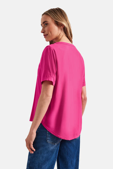 Blouse rose de STREET ONE à manches courtes, coupe ample, avec ourlet arrondi, vue de côté portée avec un jean.
