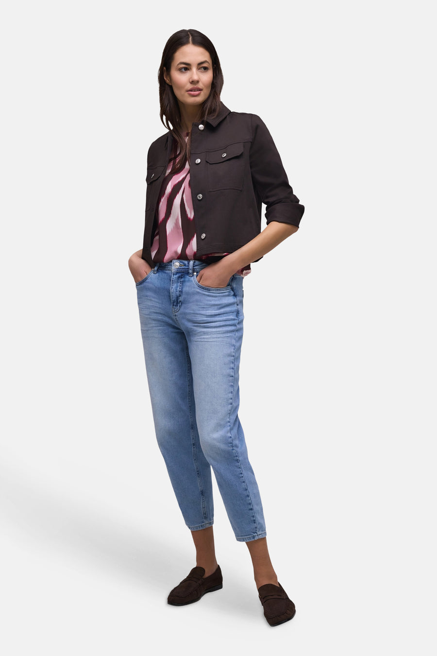 Multikleurige blouse van STREET ONE met abstract patroon in roze, framboos en wit, gedragen onder een bruin jasje en een spijkerbroek.