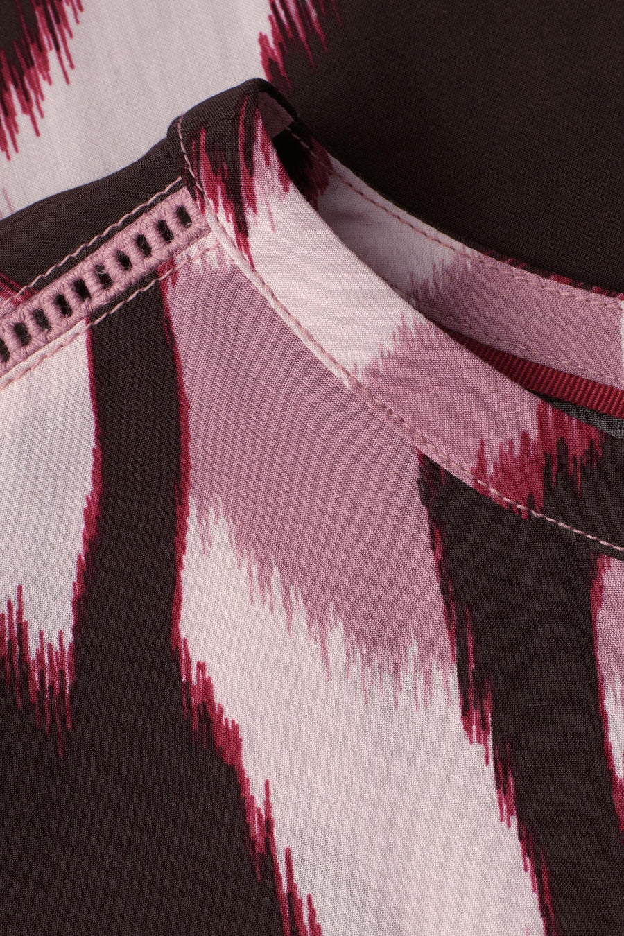 Multikleurige blouse van STREET ONE met bruin, roze en bordeauxrood ikat-patroon en een textuurpaspoortdetail bij de kraag.