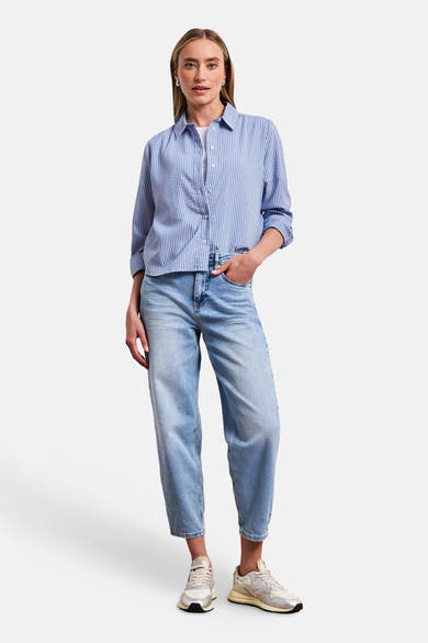 Chemise seersucker à rayures bleues et blanches de STREET ONE, avec manches retroussées, portée avec un jean clair et des baskets.