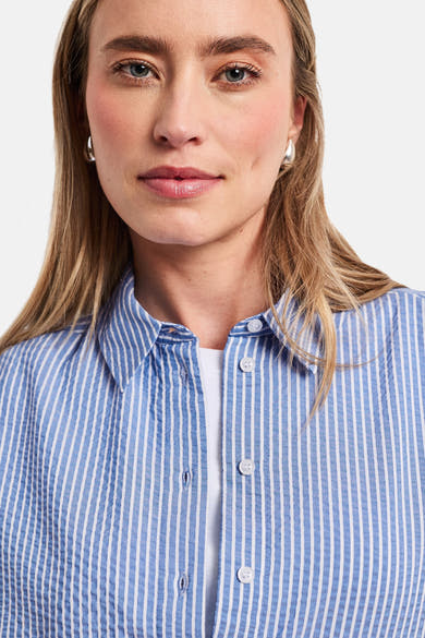 Blauw gestreept overhemd van STREET ONE met fijne witte strepen, gekreukte textuur, gedragen open over een wit T-shirt.