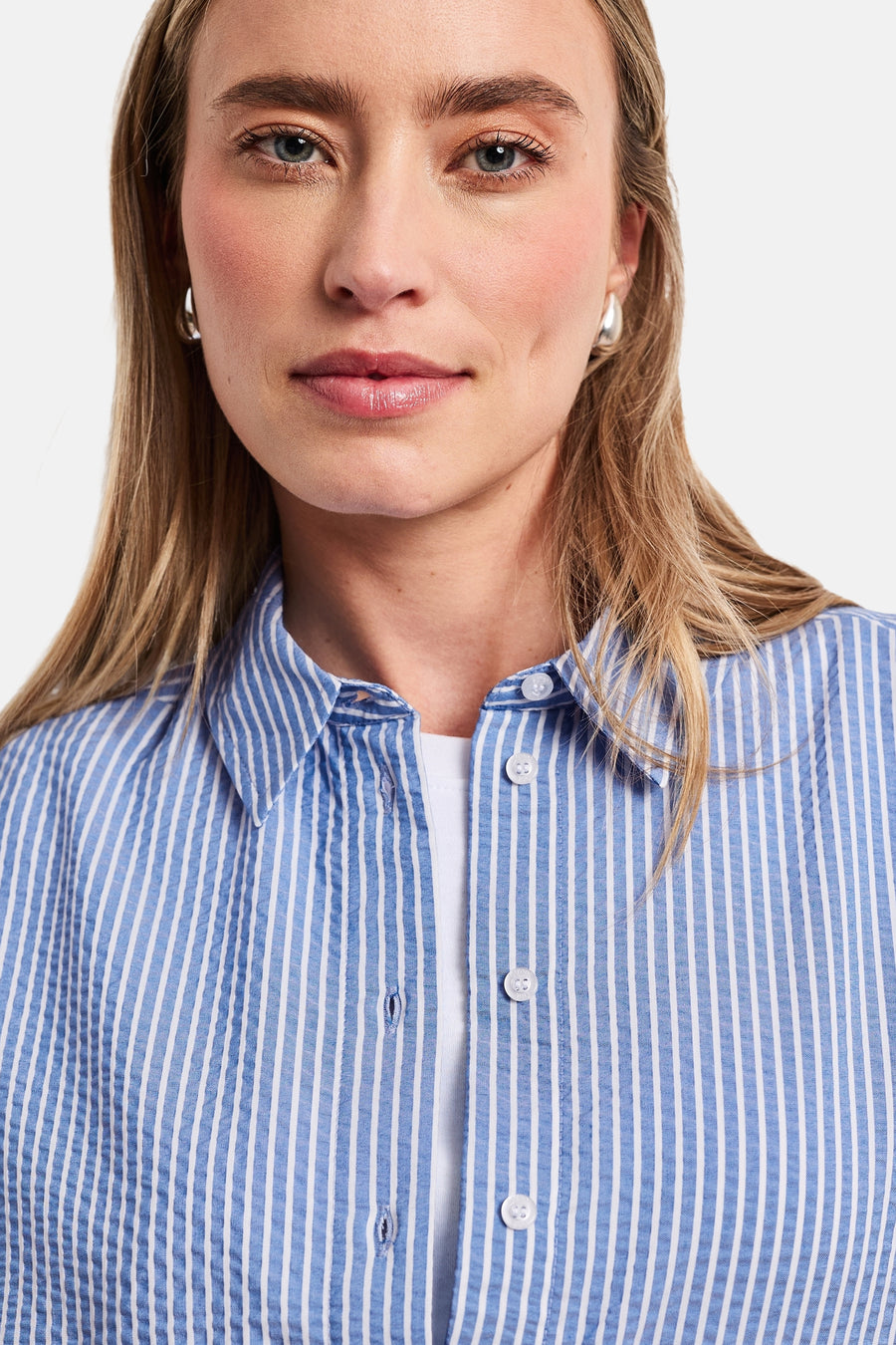 Blauw gestreept overhemd van STREET ONE met fijne witte strepen, gekreukte textuur, gedragen open over een wit T-shirt.